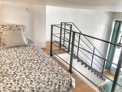 une chambre avec un lit et un escalier en colimaçon dans l'établissement Homelivia, Appart FRIDA, mezzanine, déco raffinée et balcon, à Nice