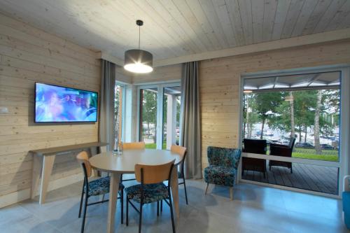 a dining room with a table and chairs and a tv at Stranda in Giżycko