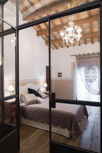 a bedroom with a bed and a chandelier at Caterina Residenza in Ravenna