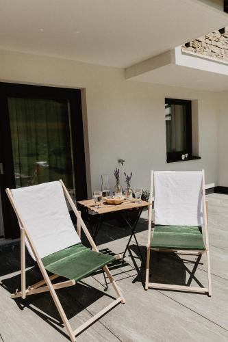 two folding chairs and a table in a living room at Appartements Almnest in Schladming