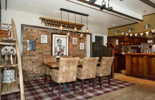 a dining room with a brick wall and a table and chairs at The Bacchus Hotel in Sutton on Sea