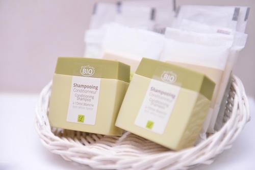 two boxes of soap in a wicker basket at Logis Hôtel Restaurant Le Chêne Vert in Rocher