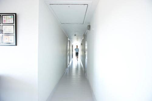 a man walking down a hallway in a building at Rødvig Kro og Badehotel in Rødvig
