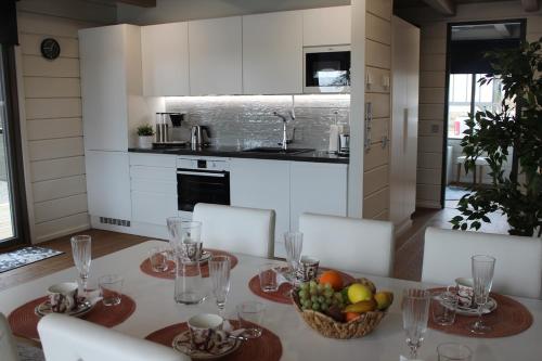 a kitchen with a table with a bowl of fruit on it at Naava Chalet Lumi 301 in Ähtäri