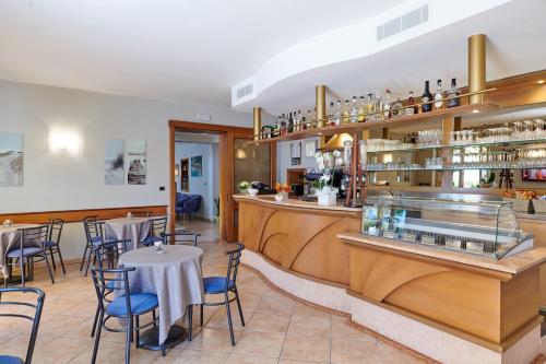 un restaurante con un bar con mesas y sillas en Albergo Del Garda, en Torri del Benaco