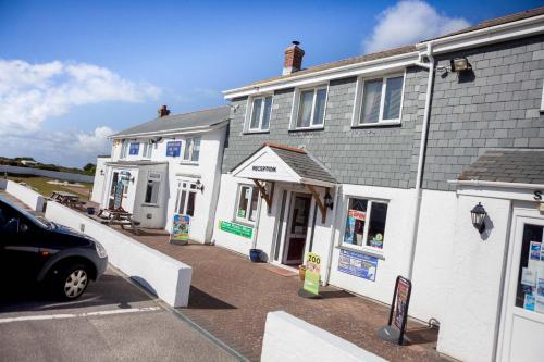 a building with a car parked in front of it at Newperran Holiday Park in Newquay
