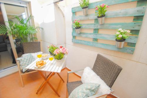 a room with a table and chairs with flowers on it at Malaga Center Flat Holidays Paseo de Reding in Málaga