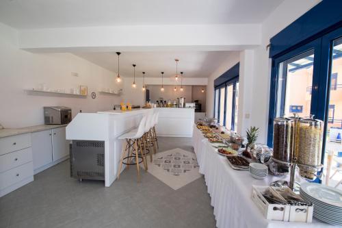 a kitchen with a long white table with food on it at Akroyiali Resort in Vasiliki