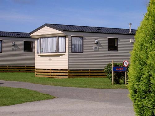 a house with a sign in front of it at Newperran Holiday Park in Newquay