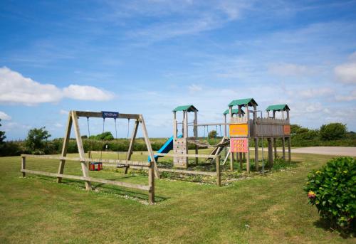 a group of playground equipment in a park at Newperran Holiday Park in Newquay