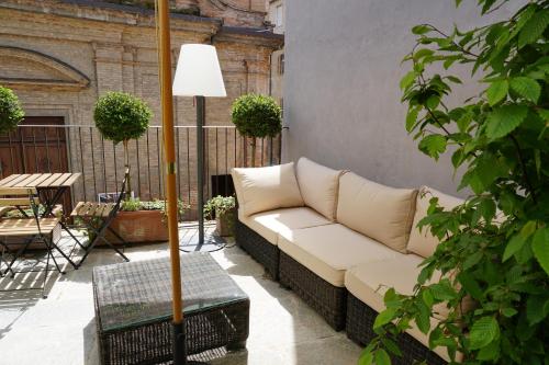 a couch sitting on a patio with a table at La Canonica - charming self-catering apartments in Nizza Monferrato in Nizza Monferrato