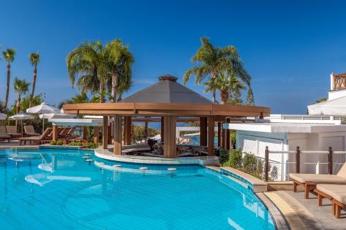 einen Pool mit Pavillon neben einem Gebäude in der Unterkunft Mediterranean Beach Hotel in Limassol