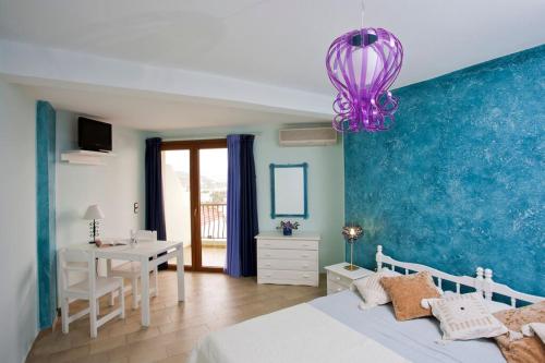 a bedroom with a bed and a purple chandelier at Polydor in Tolo