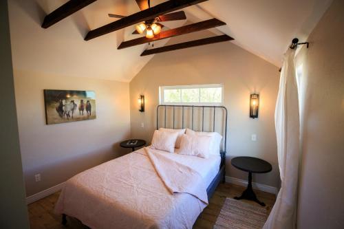 a bedroom with a bed with white sheets and a window at Hillside Colorado Cottages in Hillside