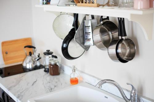 a kitchen sink with pots and pans hanging from a shelf at Hillside Colorado Cottages in Hillside