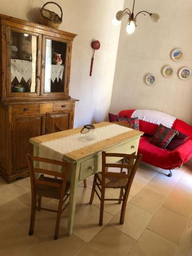 a living room with a table and chairs and a couch at Borgoincorte in Martano