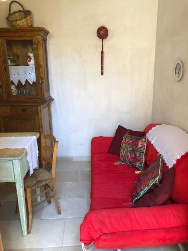 a living room with a red couch and a table at Borgoincorte in Martano