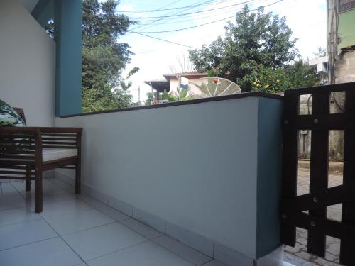 a balcony with a fence and a bench and a window at Pousada Quatro Estacoes in Trindade