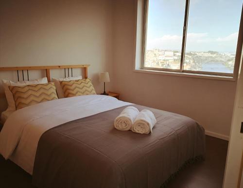 ヴィラ・ノヴァ・デ・ガイアにあるApartamento "La peinture de Porto"のベッドルーム1室(窓のあるベッド1台にタオル2枚付)