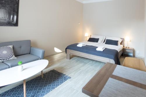 a bedroom with a king sized bed and a couch at Penzion Apartmány Resident in Poděbrady