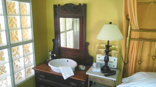 a bathroom with a sink and a mirror on a dresser at Port Albert Inn and Cottages in Port Albert