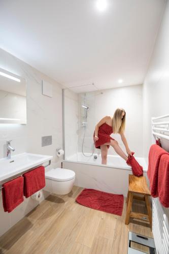 a woman standing in a bath tub in a bathroom at Hotel Garni Jägerhof in Sigmaringen