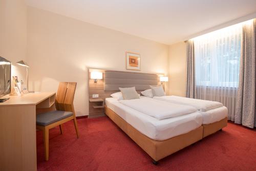 a hotel room with a bed and a desk and a computer at Comfort Garni Stadtzentrum Hotel in Bielefeld