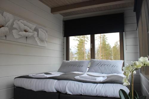 una cama en una habitación con ventana en Naava Chalet Pyry (201), en Ähtäri
