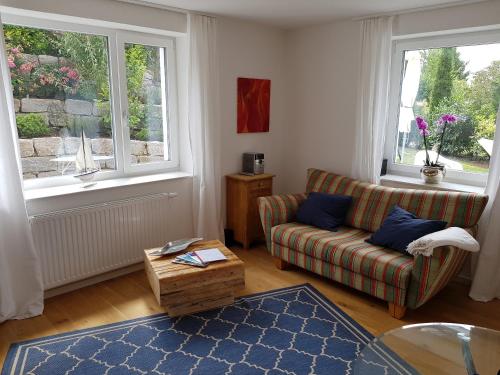 uma sala de estar com um sofá e duas janelas em Business Apartment Ravensburg - sonnig, zentral & ruhig em Ravensburg