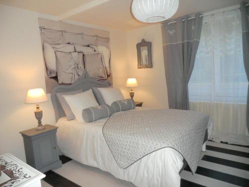 a bedroom with a white bed with pillows and a window at Givernel in Giverny