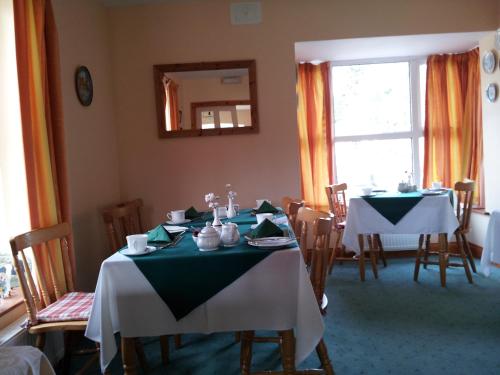 a dining room with two tables and a mirror at Ashfield B&B in Kenmare
