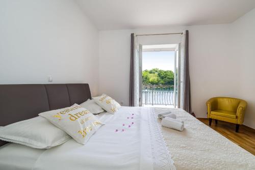 a bedroom with a large white bed with a window at Apartment NewCity in Novigrad Dalmatia