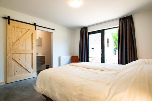 a bedroom with a bed and a sliding barn door at Brasserie/B&B De Pletsmolen in Nuth