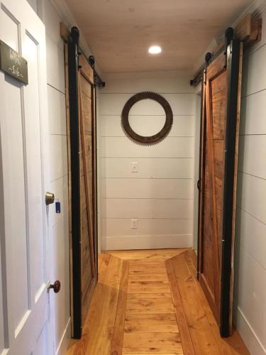 a hallway with a door and a mirror on the wall at Wind in the Willows Overnight in Jefferson
