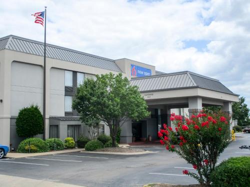 an office building with an american flag in front of it at Motel 6-Conway, AR in Conway