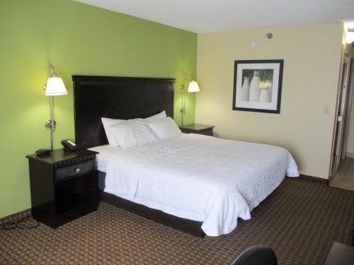 a hotel room with a large bed with white sheets at Motel 6-Conway, AR in Conway