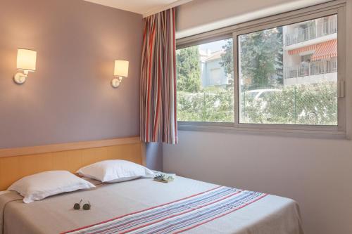 Ce lit se trouve dans un dortoir doté d'une grande fenêtre. dans l'établissement Résidence Pierre & Vacances La Promenade des Bains, à Saint-Raphaël