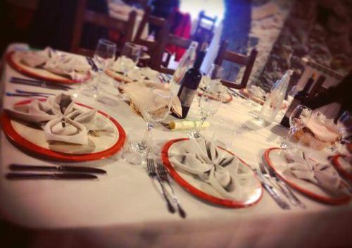 a table with red and white plates and wine glasses at Hotel Ristorante Mulino Iannarelli in San Severino Lucano