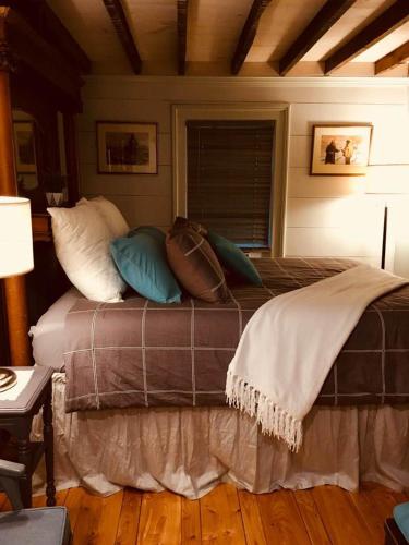 a bed with pillows on it in a room at Wind in the Willows Overnight in Jefferson