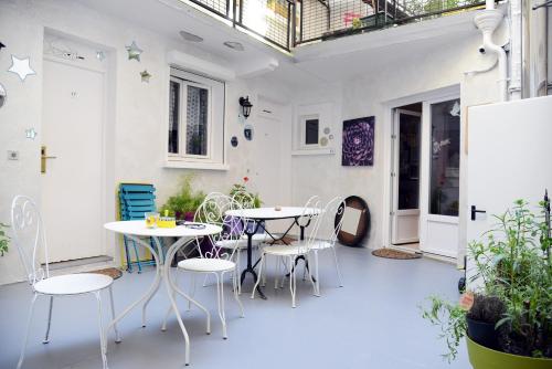 a patio with two tables and chairs and a guitar at Hôtel Malar in Paris