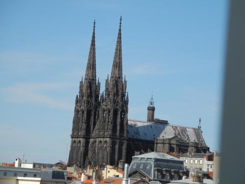 a large cathedral with two spires in a city at Apparthotel Privilodges Carré de Jaude in Clermont-Ferrand