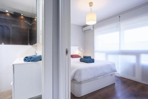ein Schlafzimmer mit einem Bett mit blauen Kissen darauf in der Unterkunft Malagueta Cool Beach Apartment in Málaga