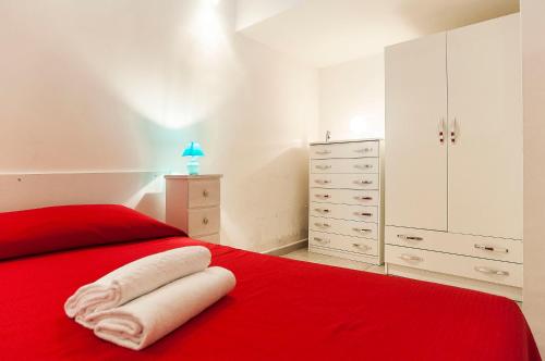 um quarto com uma cama vermelha e um cobertor vermelho em Appartamento Chicca em Sperlonga