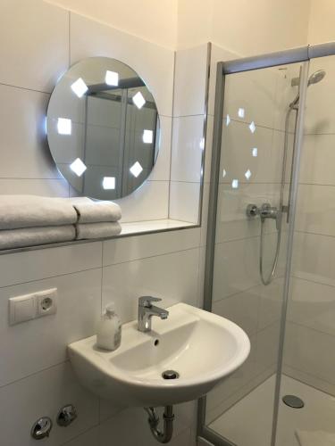 a bathroom with a sink and a shower with a mirror at Hotel Fame am Hauptbahnhof in Hamburg