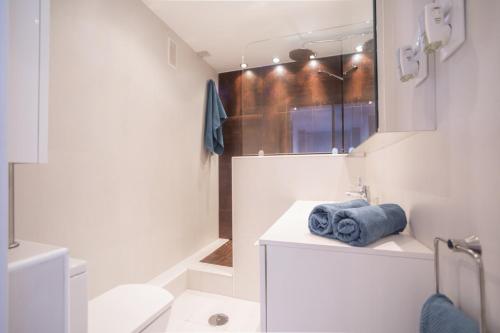 ein Badezimmer mit einem Waschbecken, einem WC und einem Spiegel in der Unterkunft Malagueta Cool Beach Apartment in Málaga