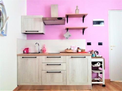 a kitchen with a pink wall and a sink at Stella Marina in Camogli
