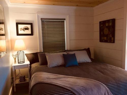 a bedroom with a bed with a blue pillow on it at Wind in the Willows Overnight in Jefferson