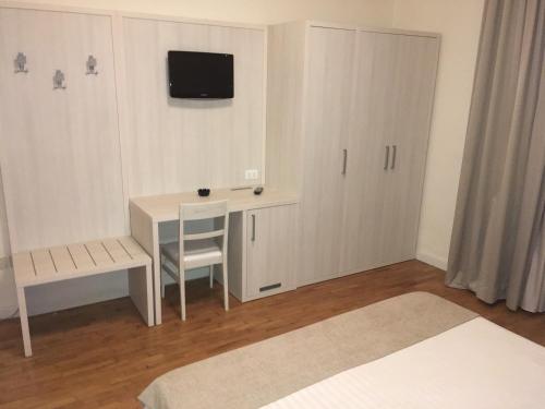 a small room with a desk and a tv on the wall at Hotel La Pace in Pontedera