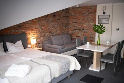 a bedroom with a bed and a couch and a table at Willa Plaza in Łeba