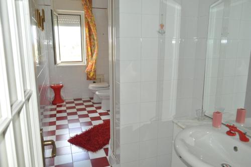 a white bathroom with a sink and a toilet at La casetta di Amélie in Agrigento